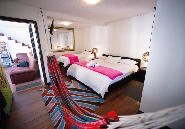 habitación con dos camas y hamaca en Baños